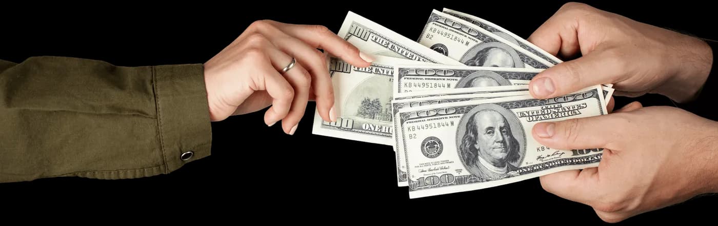 Hands exchanging US dollar banknotes